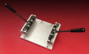 Metal mold with two black handles.